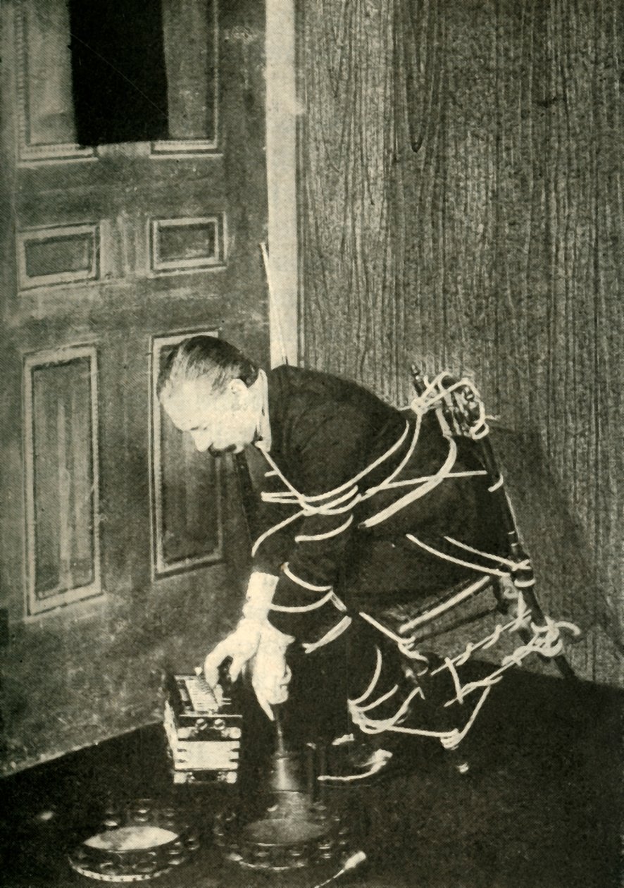 John Nevil Maskelyne wykonuje iluzję szafy duchowej, c1910. autorstwa Unbekannt