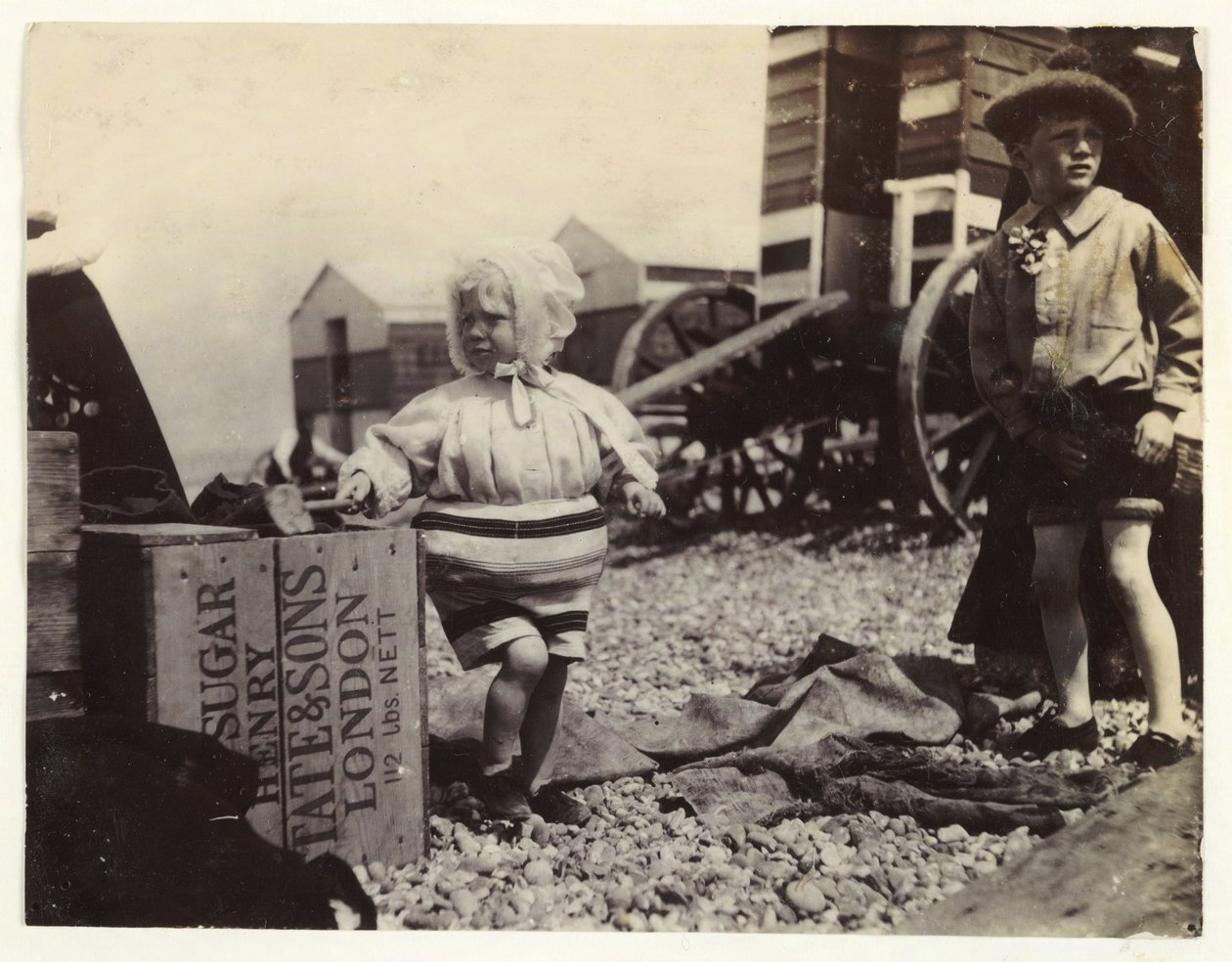 Dwoje dzieci przy maszynach do kąpieli, ok. 1895, Migawkowe zdjęcie dwójki dzieci nad morzem, stojących wśród grupy maszyn do kąpieli na plaży autorstwa Unbekannt