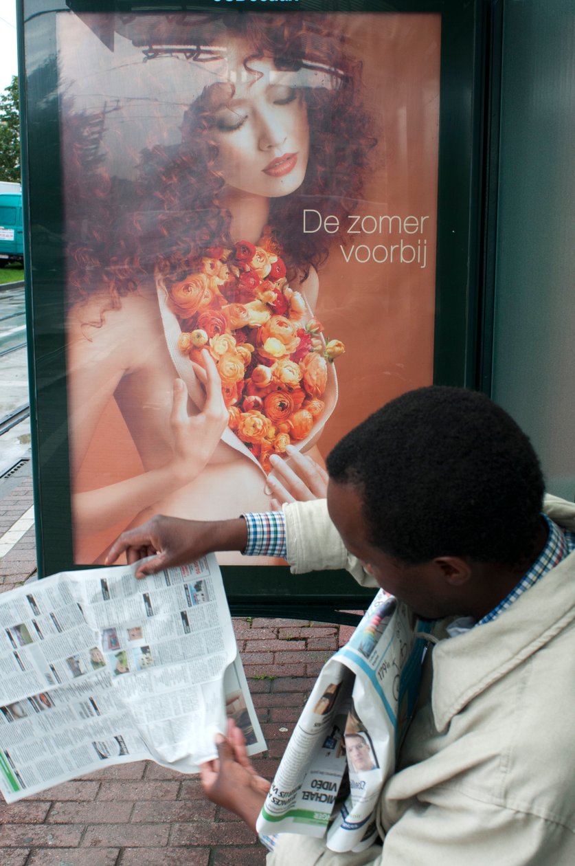 Mężczyzna czytający gazetę na przystanku tramwaju w Brukseli w Brukseli, Belgia autorstwa Unbekannt Unbekannt