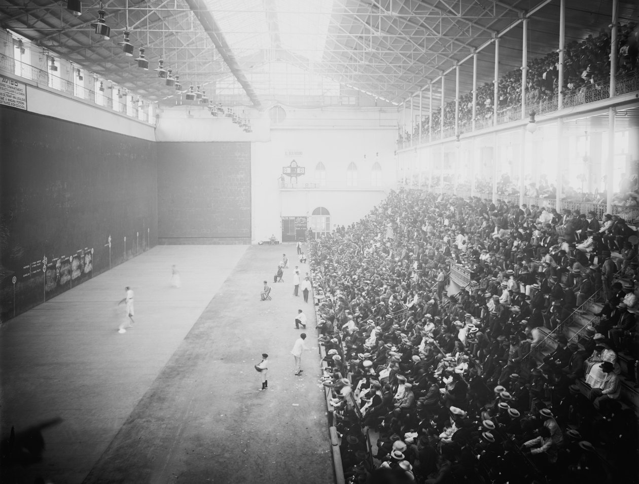 Jai alai to - sport polegający na - odbijaniu piłki - przestrzeni otoczonej ścianami poprzez przyspieszanie jej do dużych prędkości za pomocą - urządzenia ręcznego (cesta) (zdjęcie czarno-białe) autorstwa Unbekannt