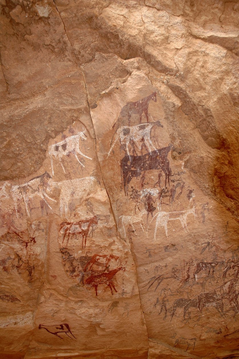 Sztuka naskalna, prehistoria: Malowidło naskalne przedstawiające grupę bydła i postaci w ozdobnym schronie w masywie Uweinat w Sudanie (Karkur-Talh lub Karkur Talh). Okres od 8000 do 3000 lat pne. Fotografia autorstwa Unbekannt
