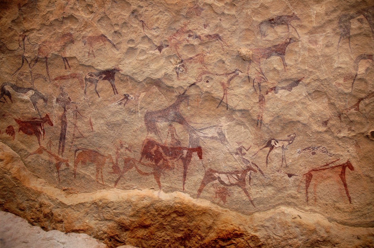 Sztuka naskalna, prehistoria: Malowidło naskalne przedstawiające grupę bydła i polichromowane postacie (pasterze i łucznicy) w ozdobnym schronie w masywie Uweinat w Sudanie. Okres od 8000 do 3000 lat pne. Fotografia autorstwa Unbekannt