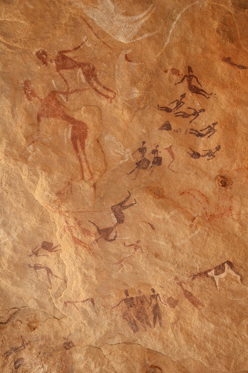Sztuka naskalna, prehistoria: Malowidło naskalne przedstawiające dużą grupę postaci i bydła w ozdobnym schronie w masywie Uweinat w Egipcie. (Okres od 8000 do 3000 lat pne). Fotografia autorstwa Unbekannt