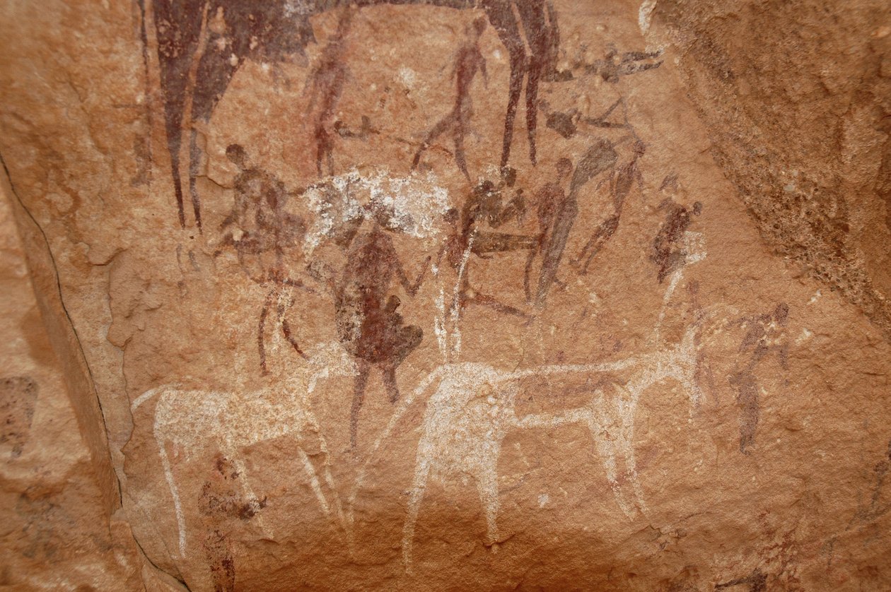 Sztuka naskalna, prehistoria: Malowanie naskalne postaci i krów w ozdobnym schronie w masywie Uweinat w Sudanie (Karkur-Talh lub Karkur Talh). Okres od 8000 do 3000 lat pne. Fotografia autorstwa Unbekannt