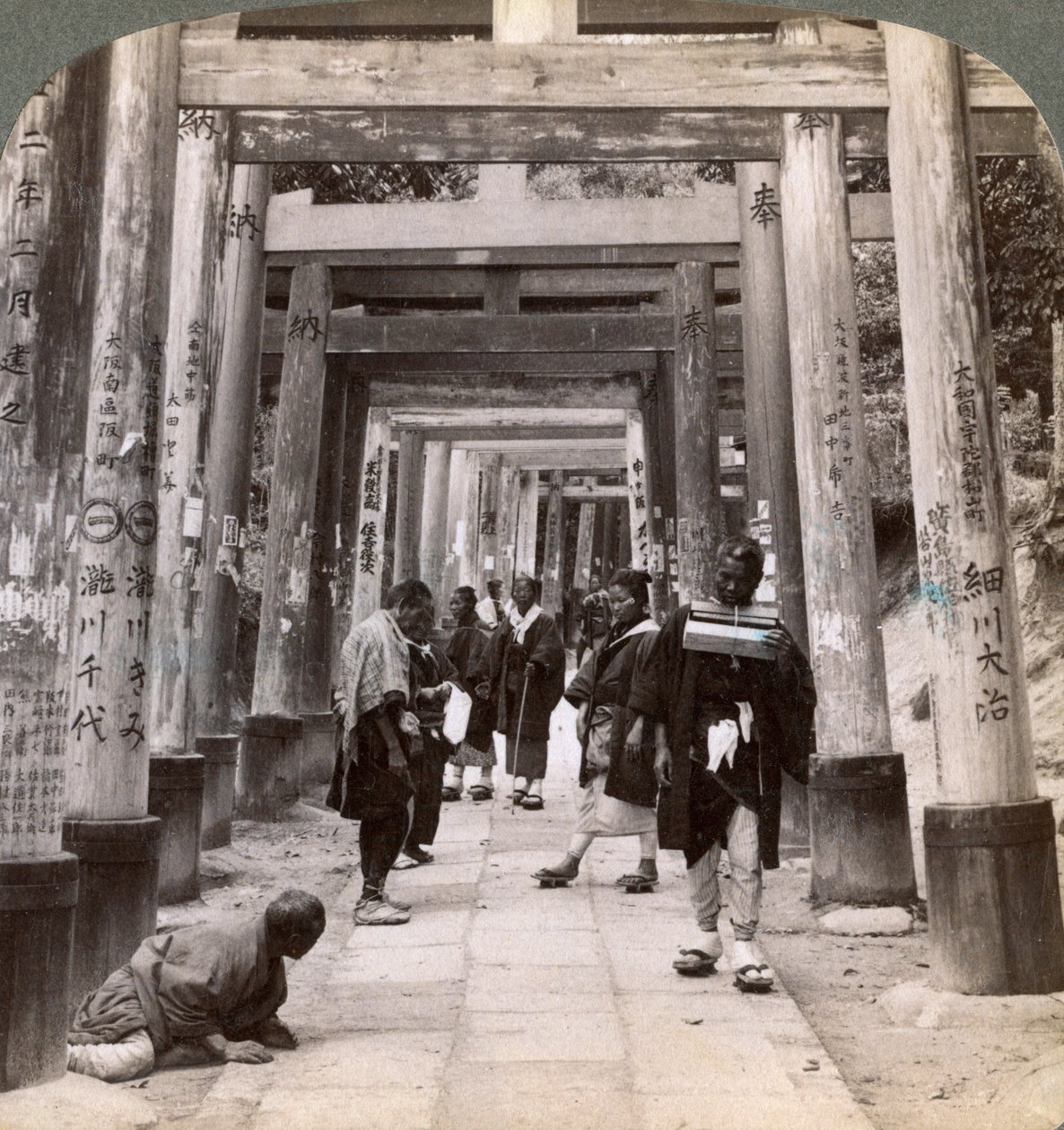 Wchodzenie i odchodzenie pod długimi rzędami świętych torii, świątynia Shinto w Inari, Kioto, Japonia, 1904 autorstwa Underwood and Underwood