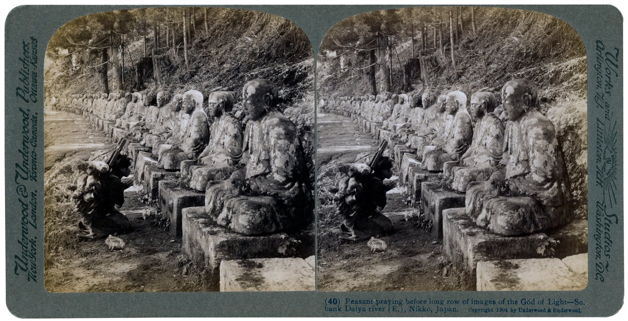 Chłop modlący się przed rzędem posągów Boga Światła, rzeka Daiya, Nikko, Japonia, 1904. autorstwa Underwood and Underwood