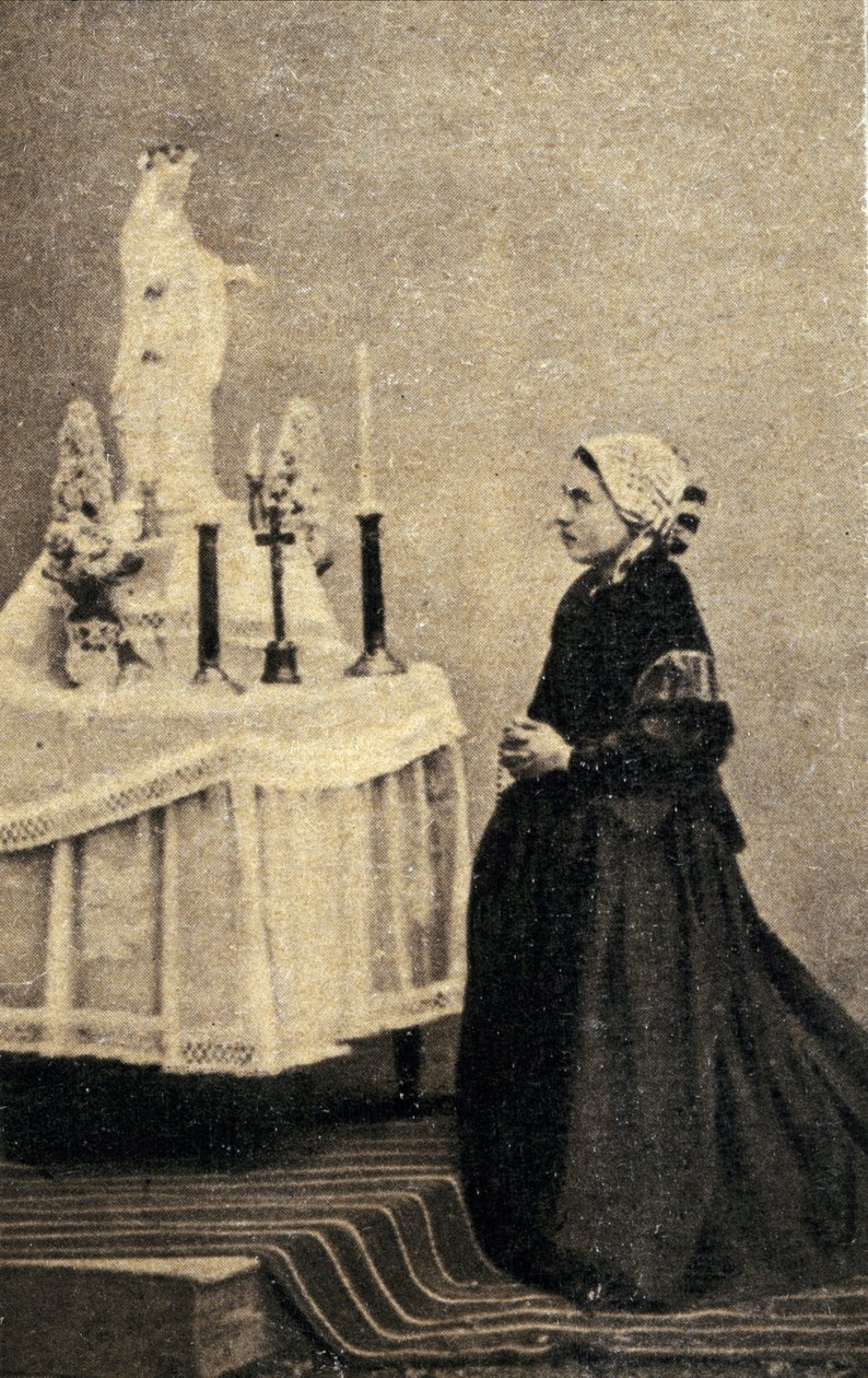 Bernadeta Soubirous klęczy przed ołtarzem z Matką Boską autorstwa Unknown photographer