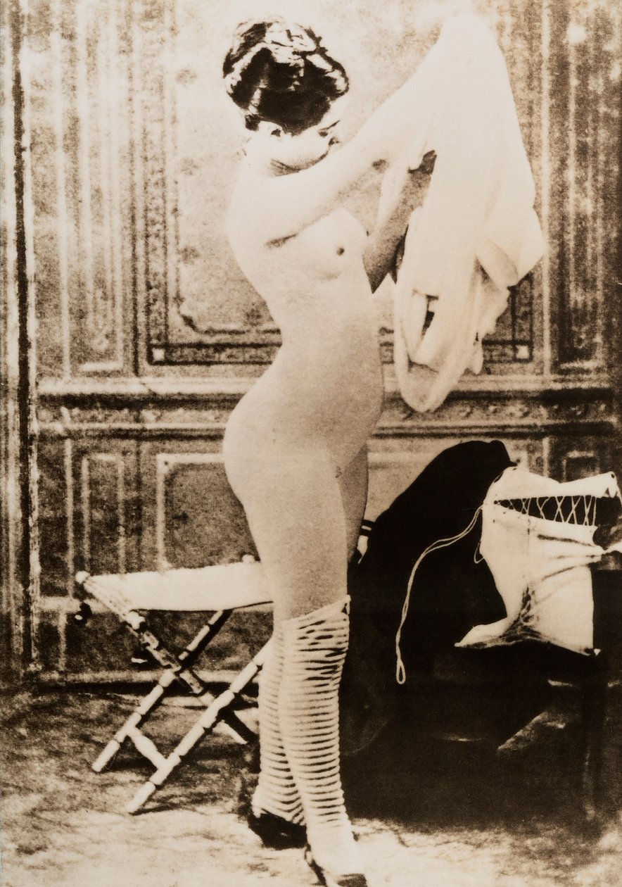 Pełnometrażowy nagi portret młodej kobiety ubierającej się. autorstwa Unknown photographer