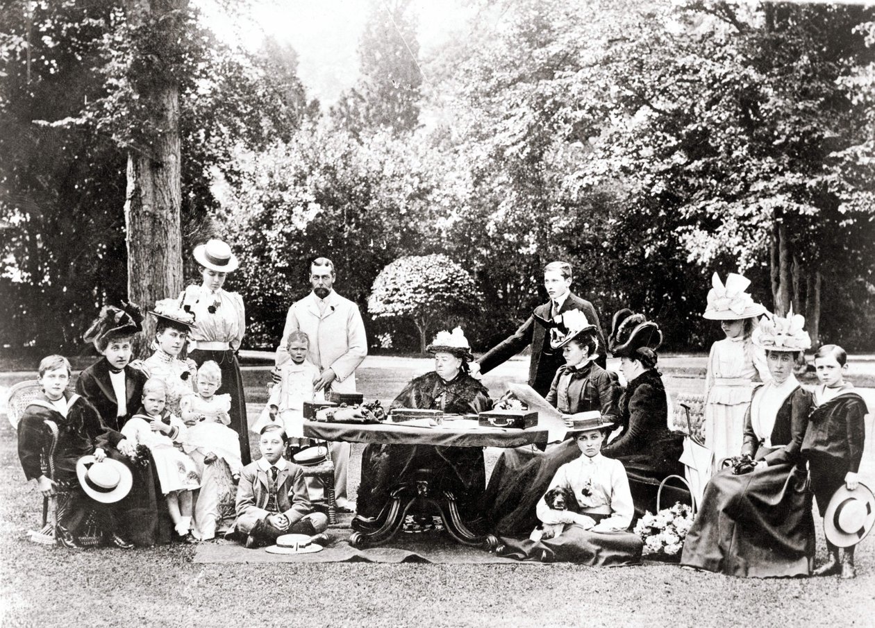 Członkowie brytyjskiej rodziny królewskiej, w tym król Jerzy V, król Edward VIII wokół królowej Wiktorii na przyjęciu w ogrodzie. Fotografia w latach 1895-1901. autorstwa Unknown photographer