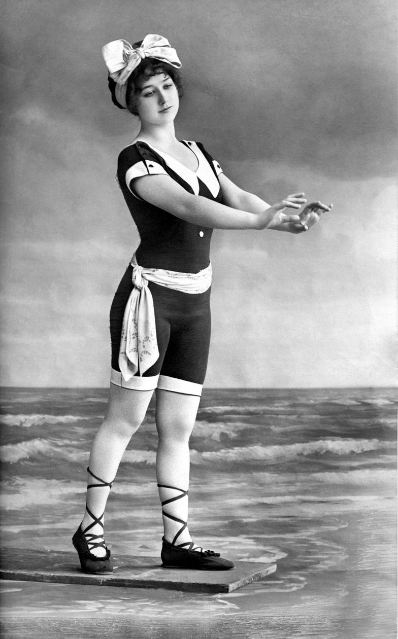 Kobieta w kostiumie kąpielowym i butach plażowych. autorstwa Unknown photographer