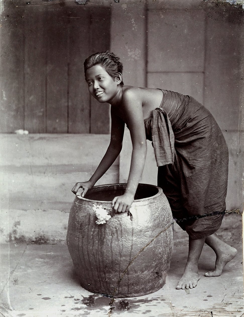 Młoda uśmiechnięta Tajka pchająca duży kontener autorstwa Unknown photographer