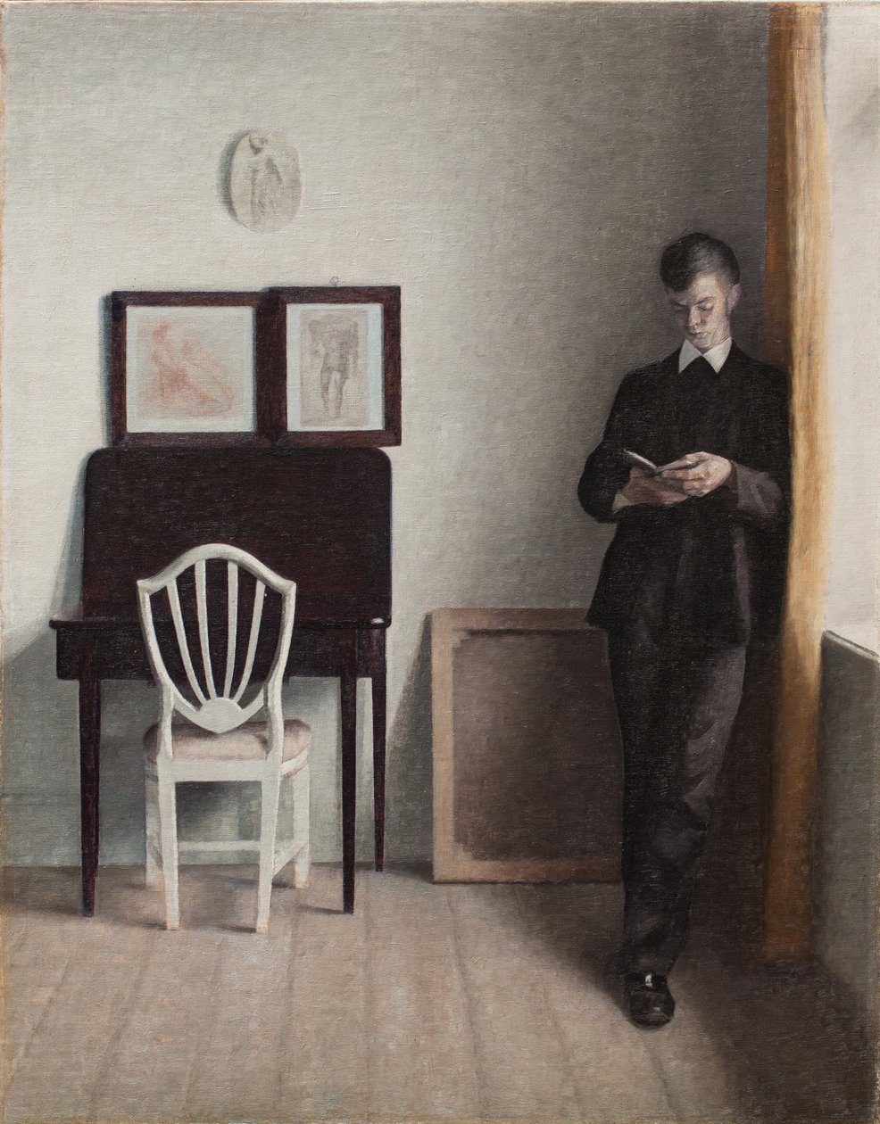 Wnętrze z czytającym młodym mężczyzną autorstwa Vilhelm Hammershoi