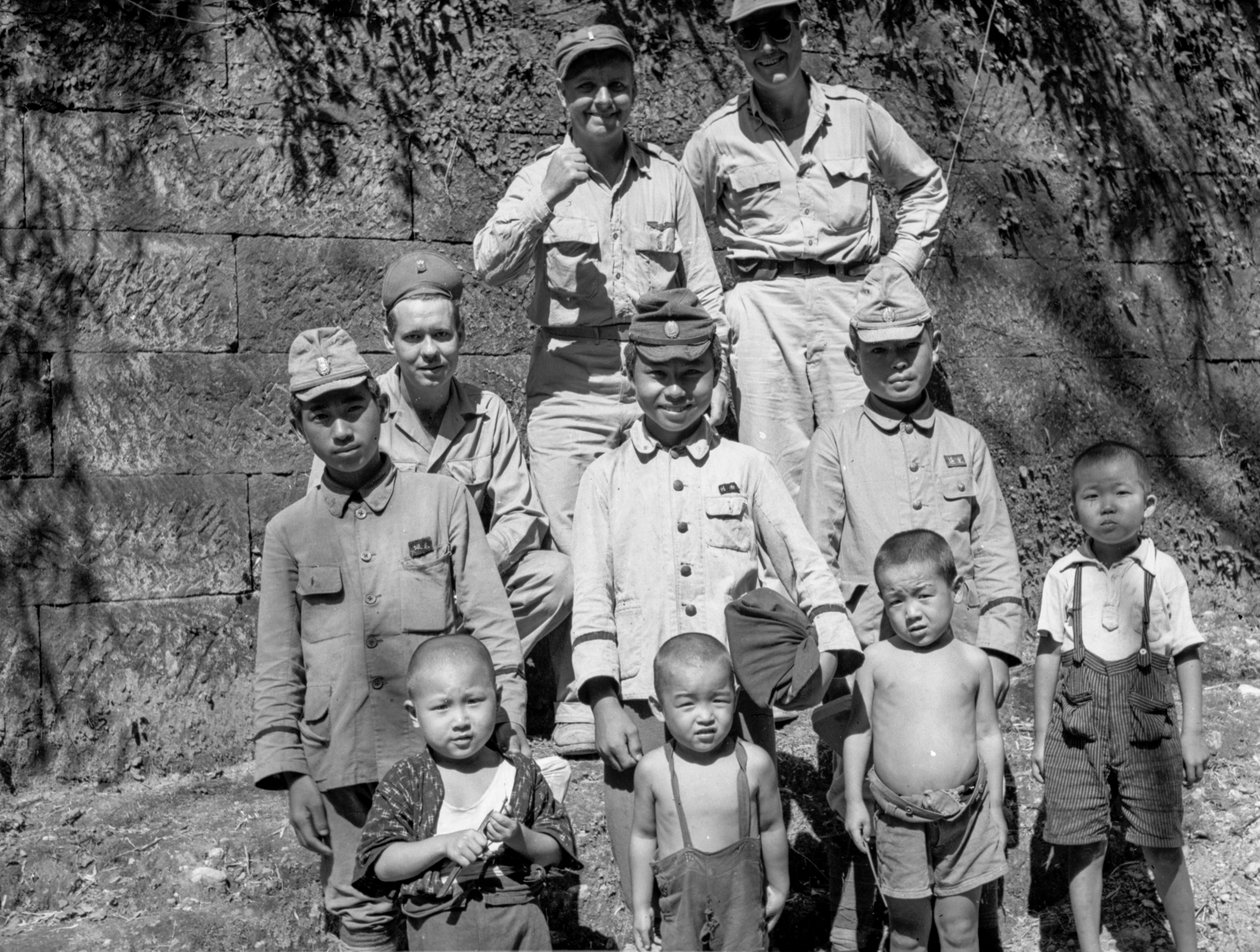 Amerykańscy żołnierze z japońską rodziną pozują razem po kapitulacji Japonii i... autorstwa Volkmar Wentzel