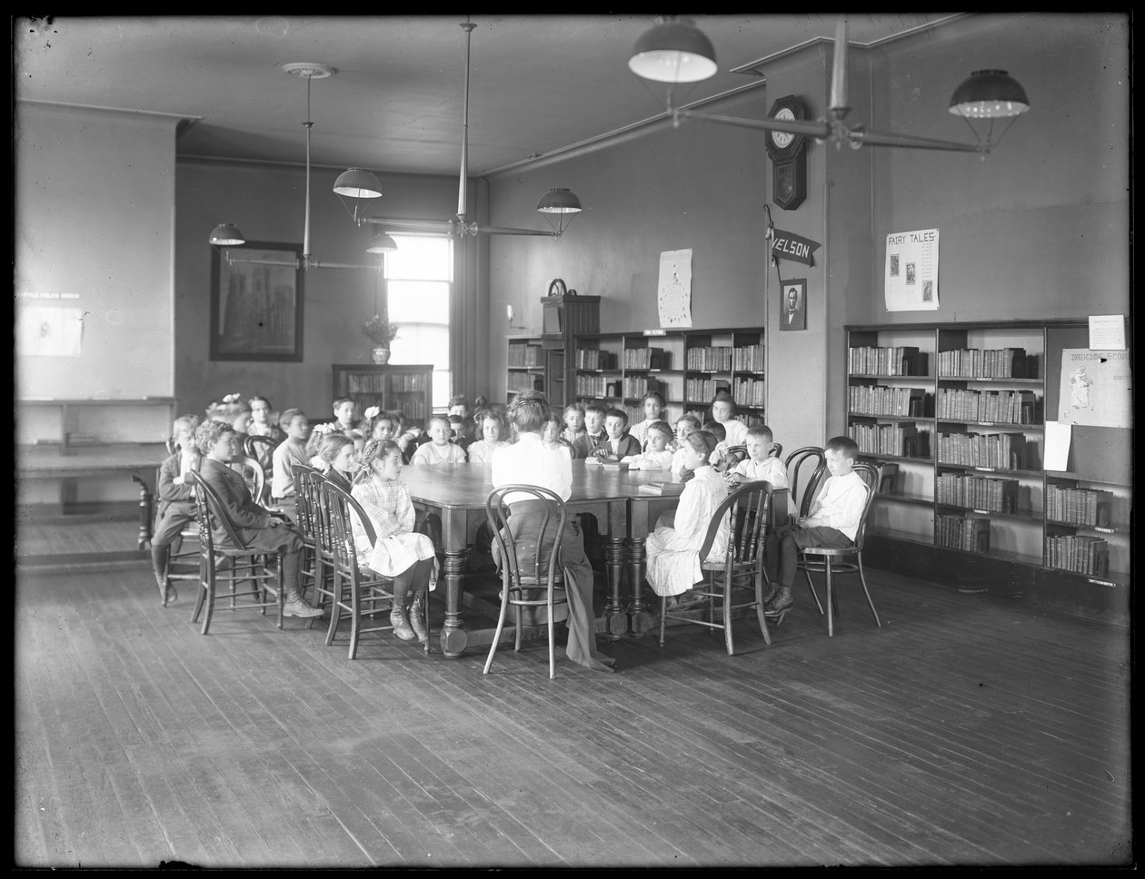 Dzieci słuchają kobiety w czytelni niezidentyfikowanej filii Biblioteki Publicznej Queens Borough, ok. 1910 autorstwa William Davis Hassler