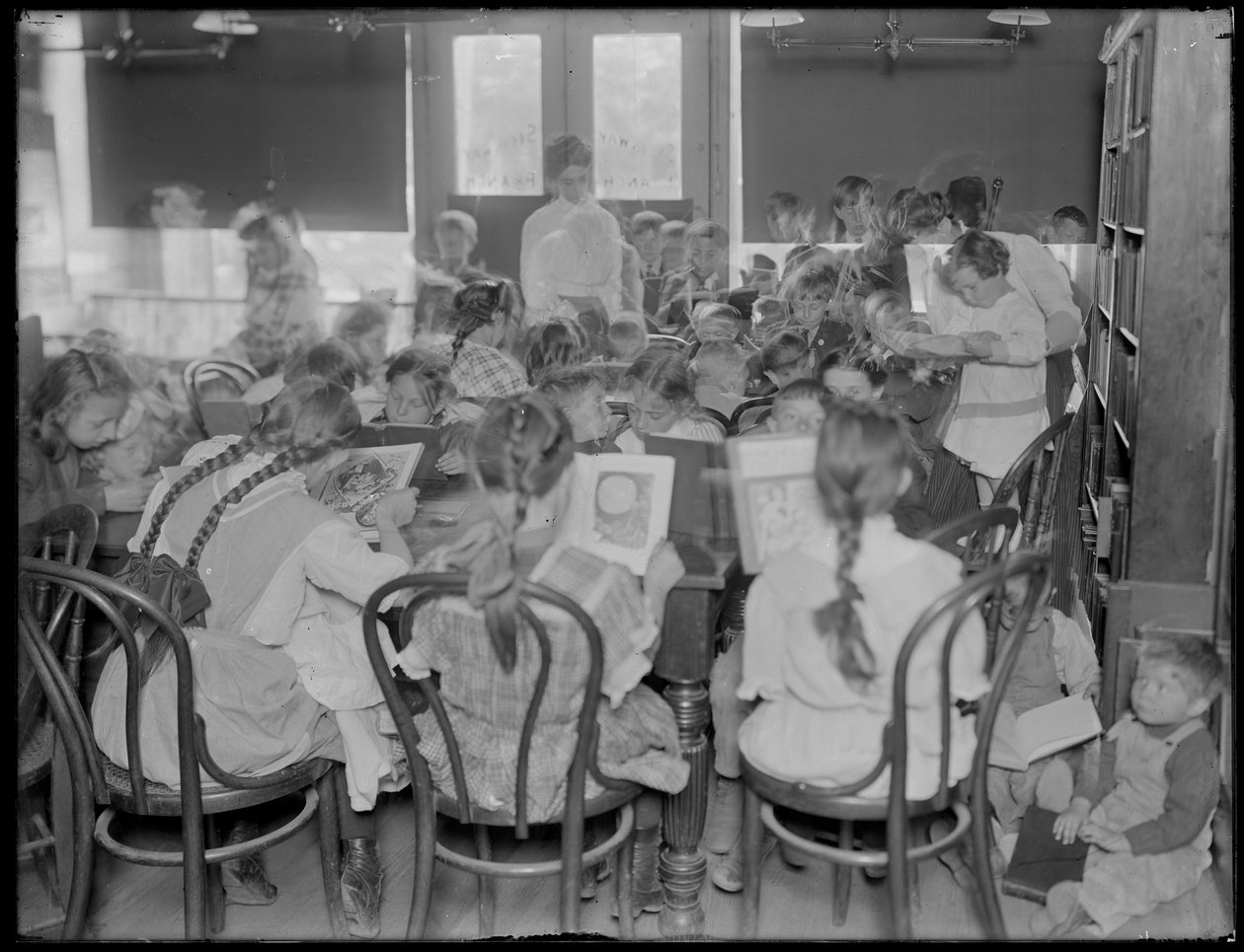 Dzieci czytające w czytelni niezidentyfikowanej filii Biblioteki Publicznej Queens Borough, ok. 1910. autorstwa William Davis Hassler