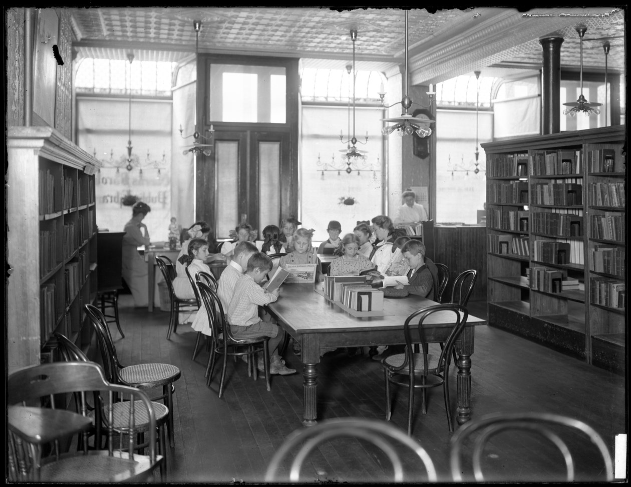 Dzieci czytające w czytelni niezidentyfikowanej filii biblioteki publicznej w dzielnicy Queens, ok. 1910 r. autorstwa William Davis Hassler