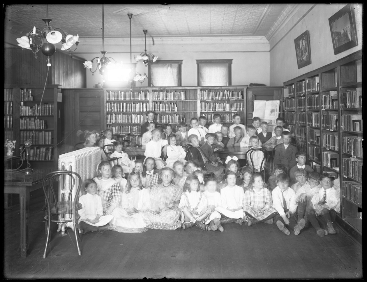 Portret grupowy dzieci w czytelni niezidentyfikowanej filii biblioteki publicznej w dzielnicy Queens, ok. 1910 r. autorstwa William Davis Hassler