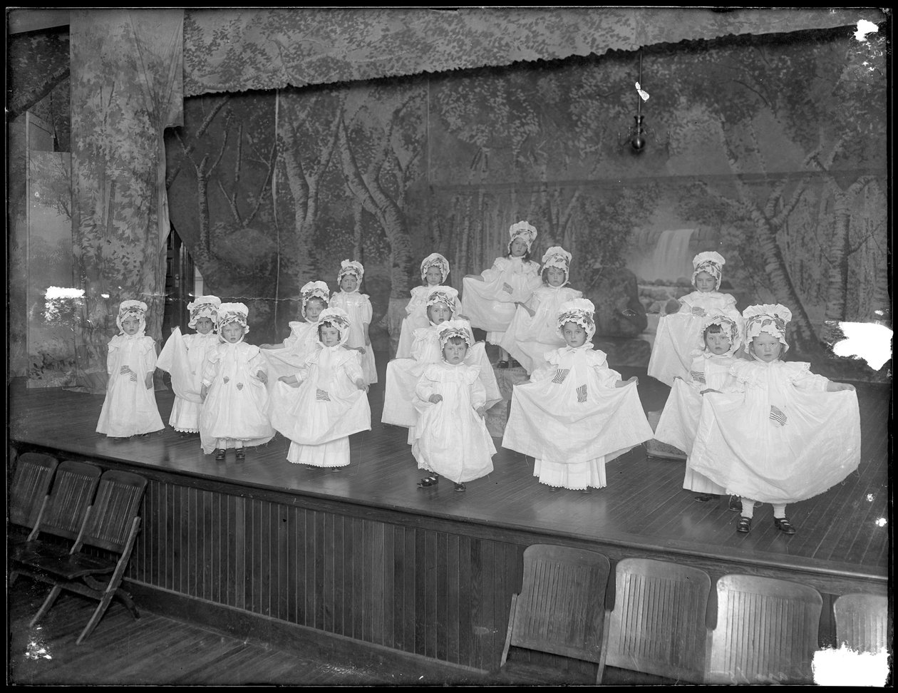 Przedszkolaki na scenie: bardzo małe dziewczynki występują na małej scenie, prawdopodobnie w rzymskokatolickim azylu dla sierot, Kingsbridge, Bronx, ok. 1911 autorstwa William Davis Hassler