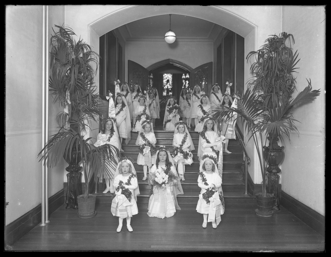 Dziewczynki w rzymskokatolickim azylu dla sierot w Kingsbridge, Bronx, wracają z kaplicy w białych sukniach z wieńcami i wieńcami, 20 października 1914 autorstwa William Davis Hassler