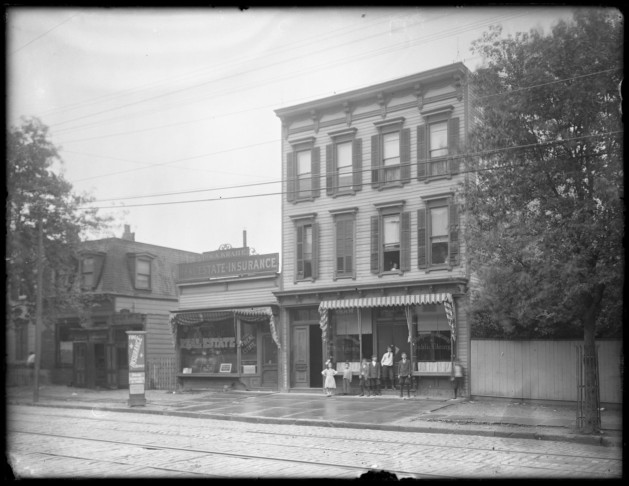 Siedmioro dzieci pozuje przed niezidentyfikowanym oddziałem Biblioteki Publicznej Queens Borough, Nowy Jork, ok. 1910 r. autorstwa William Davis Hassler