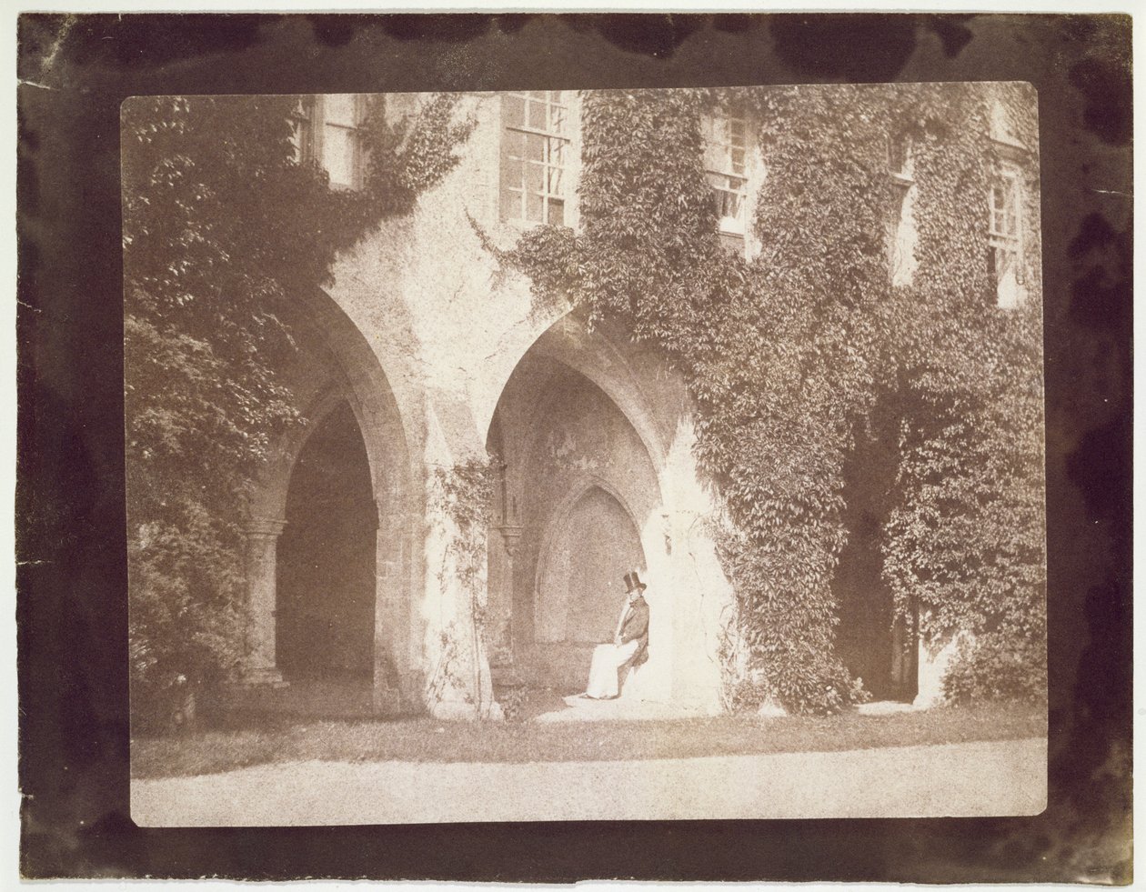 Wielebny Calvert Jones siedzący w Cloisters, Laycock Abbey, ok. 1847 r. (odbitka na papierze solnym z negatywu kalotypii) autorstwa William Henry Fox Talbot