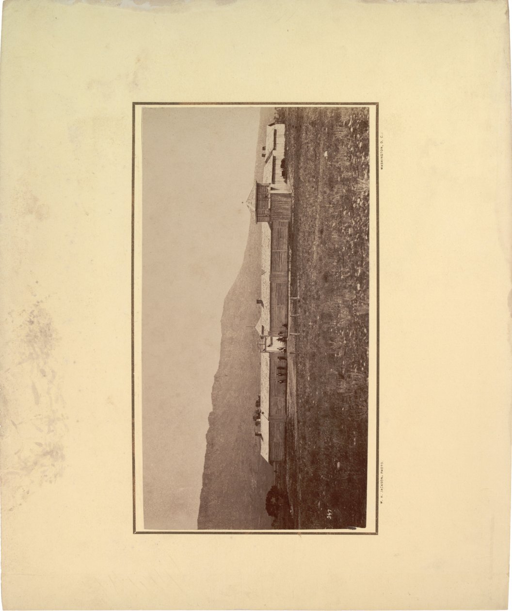 Widok palisady z kilkoma mężczyznami zgromadzonymi przed bramą wjazdową, 1871 (zdjęcie w sepii) autorstwa William Hicks Jackson