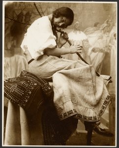 [Siedząca modelka trzymająca gałąź drzewa] autorstwa Alphonse Maria Mucha