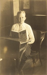 Chłopiec czytający Porwany (zdjęcie czarno-białe) autorstwa American Photographer