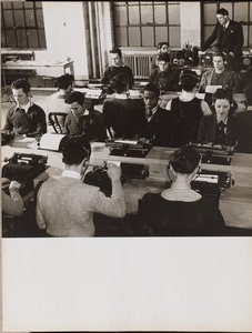 [Ludzie siedzą przed maszynami do pisania, nosząc słuchawki].
