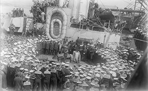 Marynarze tłoczą się wokół australijskiego premiera Hon Williama Morrisa (Billy) Hughesa, który przemawia do nich na pokładzie HMAS Australia w stoczni w Devon w Anglii, 21 maja 1916 r. autorstwa Australian Photographer
