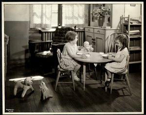 Dwie niewidome, niedowidzące dziewczyny jedzące przy małym stoliku z lalką w nowojorskim stowarzyszeniu dla niewidomych, 111 East 59th Street, Nowy Jork, 1933 (srebrny odbitka żelatynowa)