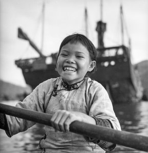 Portret młodej dziewczyny w sampanie w porcie Aberdeen w Hongkongu.