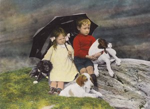 Chłopiec i dziewczynka z trzema psami pod parasolem (zdjęcie pokolorowane) autorstwa English Photographer
