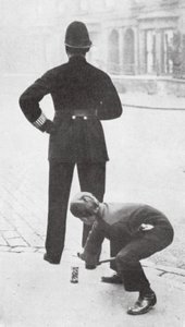 Chłopiec robiący psikusa policjantowi (zdjęcie czarno-białe) autorstwa English Photographer