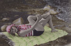 Dziewczyna leżąca na ręczniku na plaży (kolorowe zdjęcie) autorstwa English Photographer
