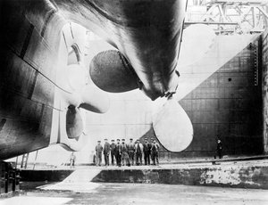 Robotnicy stojący pod jednym ze śmigieł Titanica, 31 maja 1911 r. autorstwa English Photographer