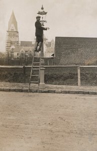 Mężczyzna wspina się po drabinie naprawiając latarnię uliczną (zdjęcie czarno-białe) autorstwa European Photographer