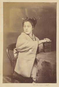 [Siedząca Japonka trzymająca przy stole album cartes-de-visite]. autorstwa Felice Beato