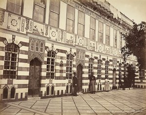 Dziedziniec domu żydowskiego w Stambouli w Syrii. W pobliżu ścian budynku pokazano trzech domowników