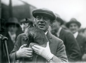 Mangabey czarnoczuby, prawdopodobnie Piegi, ze swoim opiekunem, biorący udział w zewnętrznej transmisji z londyńskiego zoo, 1925 autorstwa Frederick William Bond