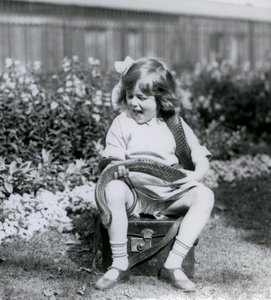 Młoda dziewczyna Betty trzymająca wschodniego węża indygo, siedząca na skórzanym bagażniku, londyńskie zoo, 1924 autorstwa Frederick William Bond
