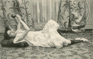 Dziewczyna leżąca na podłodze trzymająca piłkę nad głową (zdjęcie czarno-białe) autorstwa French Photographer