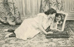 Dziewczyna uśmiechająca się do siebie w lustrze (zdjęcie czarno-białe) autorstwa French Photographer