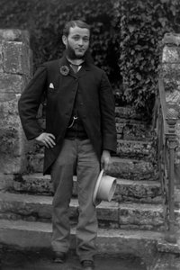 Portret młodego mężczyzny z Bourmont w Haute Marne, noszącego kokardę poborowych przy guzikarce, pozującego w ogrodzie opactwa Septfontaines. Fotografia koniec XIX wieku. Kolekcja Ducos. autorstwa French Photographer