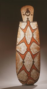 Owalna tarcza Asmat, płaskorzeźbiona ze stylizowanymi postaciami, u góry maska (drewno) autorstwa Guinean New