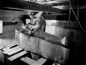 Odkrycie grobowca faraona Tutanchamona w Dolinie Królów (Egipt): w komorze grobowej, Howard Carter pracuje nad pokrywą drugiej trumny, październik 1925, fot. Harry Burton (p1568)