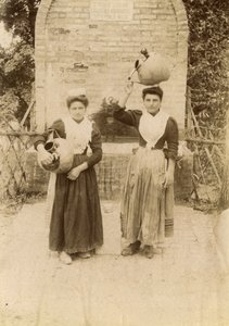 Dwie młode kobiety w tradycyjnych strojach niosące słoiki z terakoty w pobliżu studni, Marche, Włochy, ok. 1910 r. autorstwa Italian Photographer