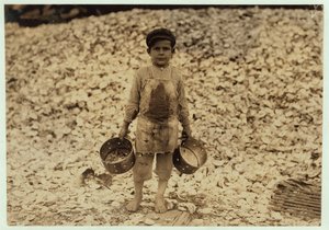 5-letni migrant zbieracz krewetek Manuel przed stosem muszli ostryg, pracujący przez drugi rok w Dunbar, Lopez, Dukate Company, Biloxi, Mississippi, 1911 autorstwa Lewis Wickes Hine