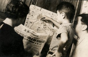 Kobieta czyta pierwszą stronę The Messenger z tytułem "Trójkolorowi machają zwycięsko z odzyskanej Adwy".