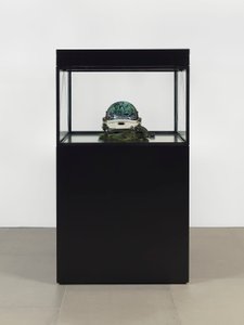 Alpha Omega, 2016 (szkło, ekran LCD, odtwarzacz multimedialny, replika czaszki, hełm kosmiczny, drewno) autorstwa Mat Collishaw